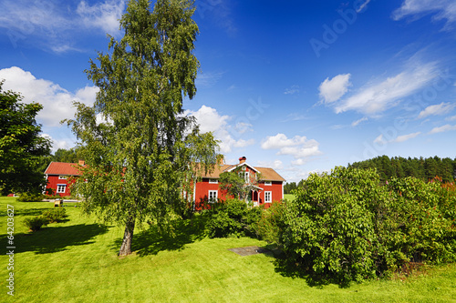 Obraz na plátne old red cottages in green lush summer surroundings