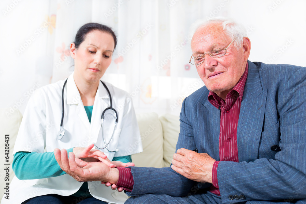 Fototapeta premium Young doctor checking senior patient blood pressure
