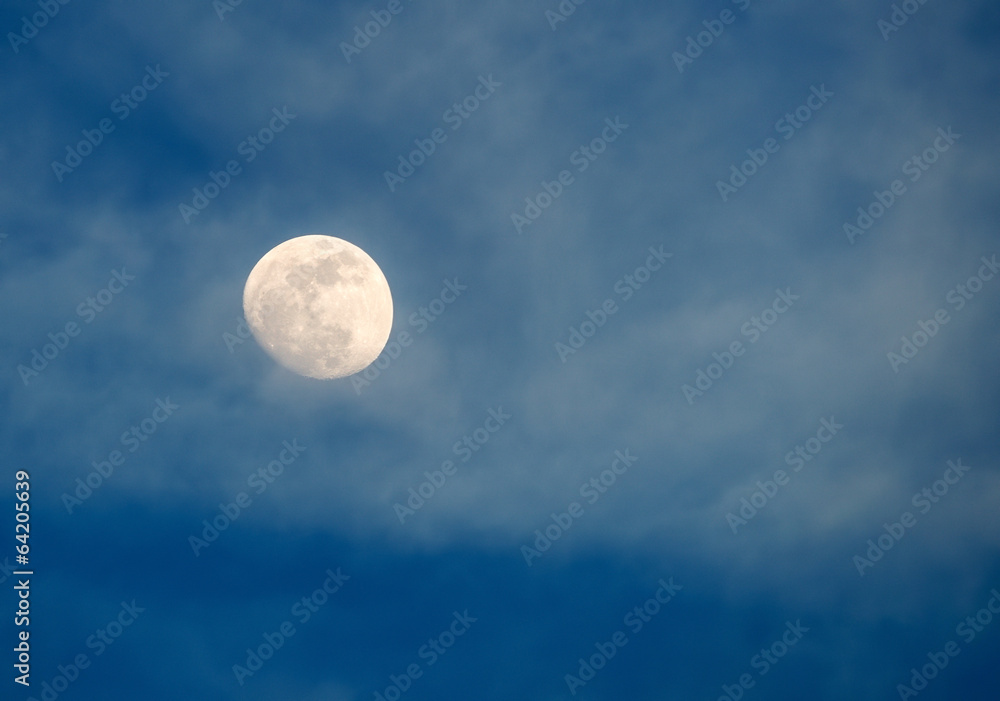 Shiny moon in cloudy skies before dusk Shiny moon in cloudy skies before dusk