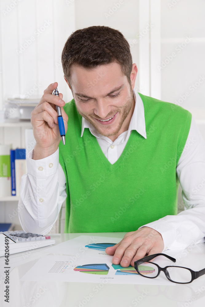 Positiv gestimmer Business Mann sitzend am Schreibtisch Positiv gestimmer Business Mann sitzend am Schreibtisch