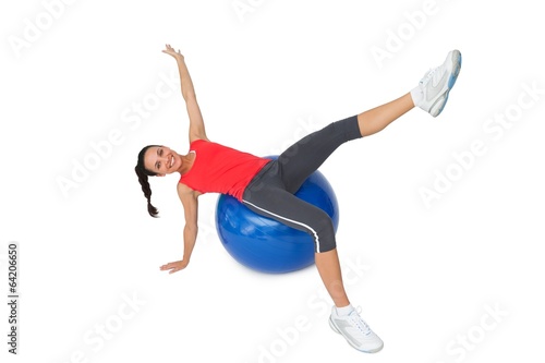 Fit young woman stretching on exercise ball