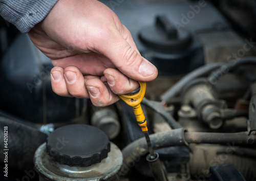 Auto Mechanic checking oil. Selective focus.