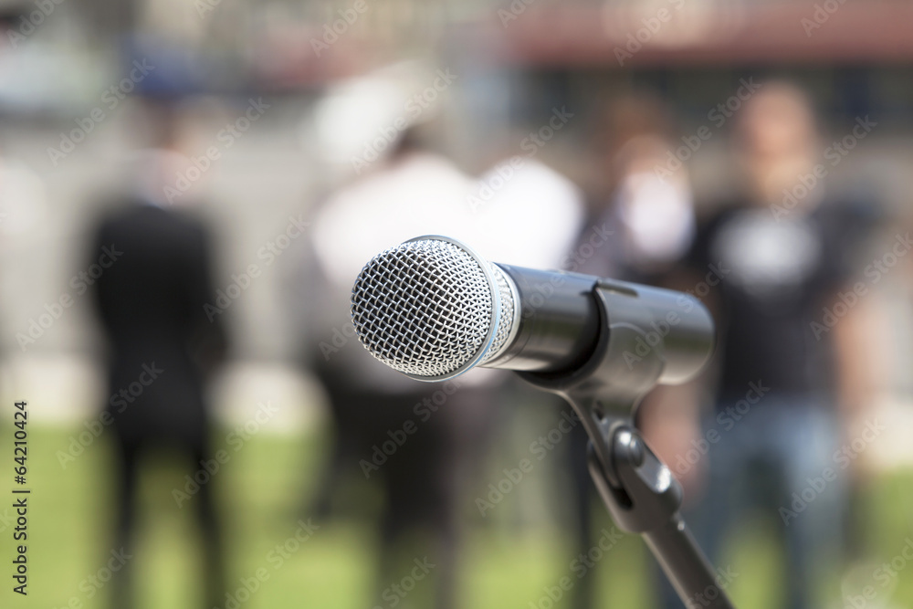 Microphone in focus against blurred audience Microphone in focus against blurred audience