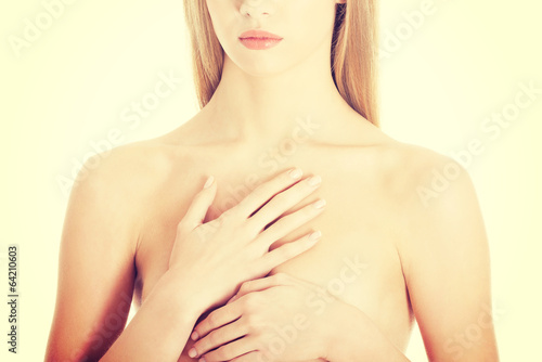 Beautiful caucasian naked woman covering her chest.