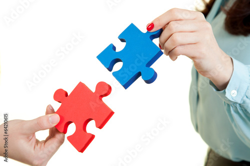 business women assembling jigsaw puzzle and