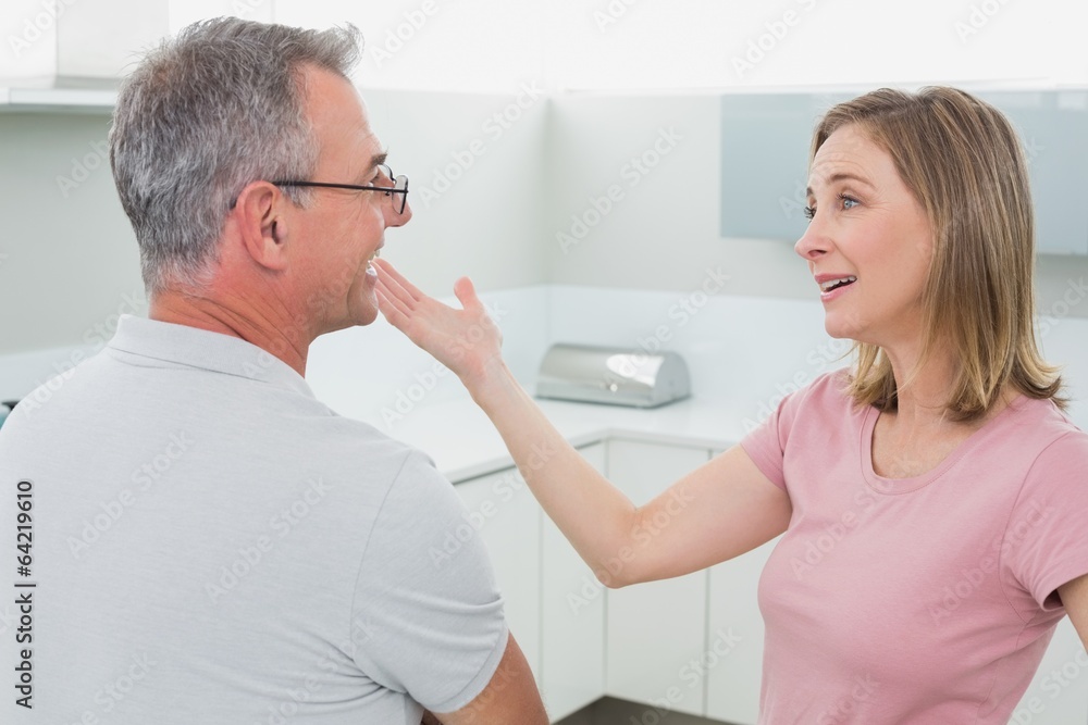 Happy couple having a conversation in kitchen