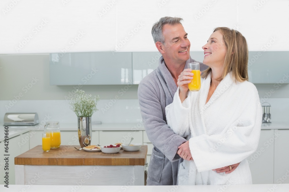 Man embracing woman from behind in kitchen Man embracing woman from behind in kitchen