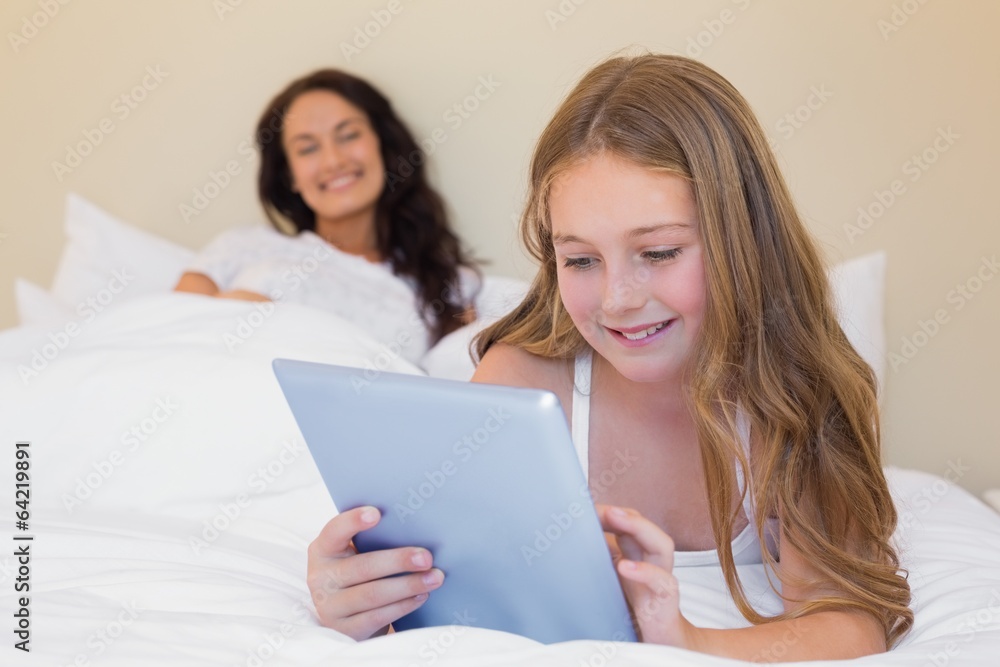 Girl using digital tablet in bed Girl using digital tablet in bed