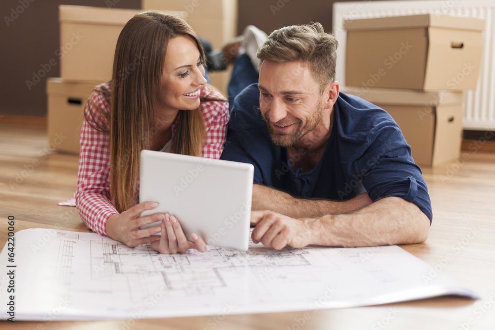 Couple arranging new apartment with digital tablet Couple arranging new apartment with digital tablet