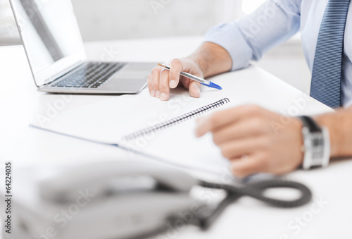 businessman writing in notebook