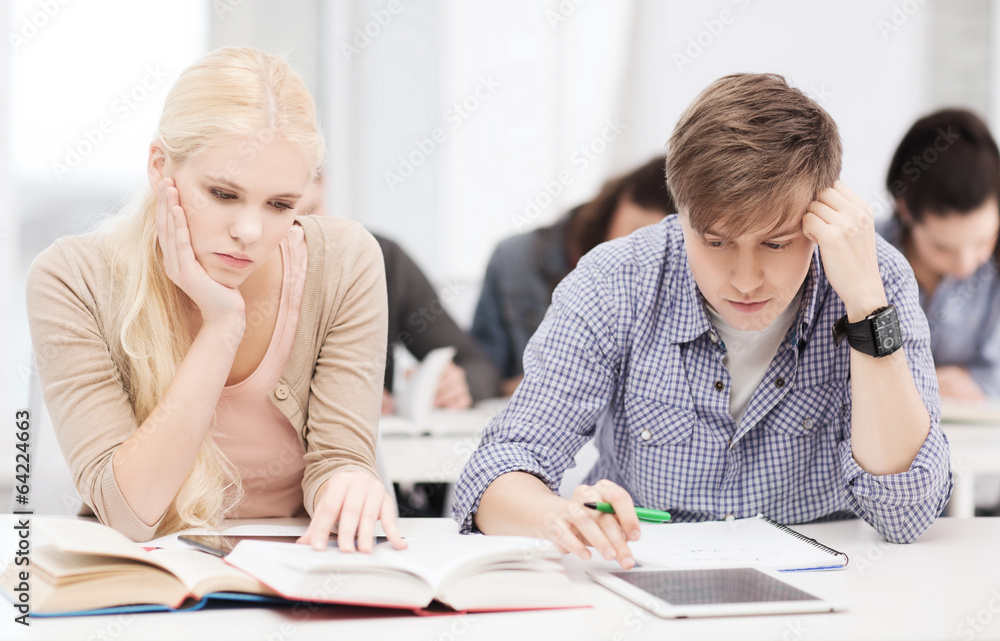 tired students with tablet pc, notebooks and books tired students with tablet pc, notebooks and books