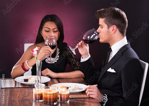 Couple Toasting Wineglasses At Restaurant Table