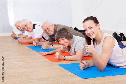 Trainer And Senior Customers At Gym