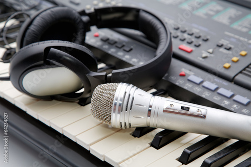Photography microphone and ear-phones lie on the keyboard