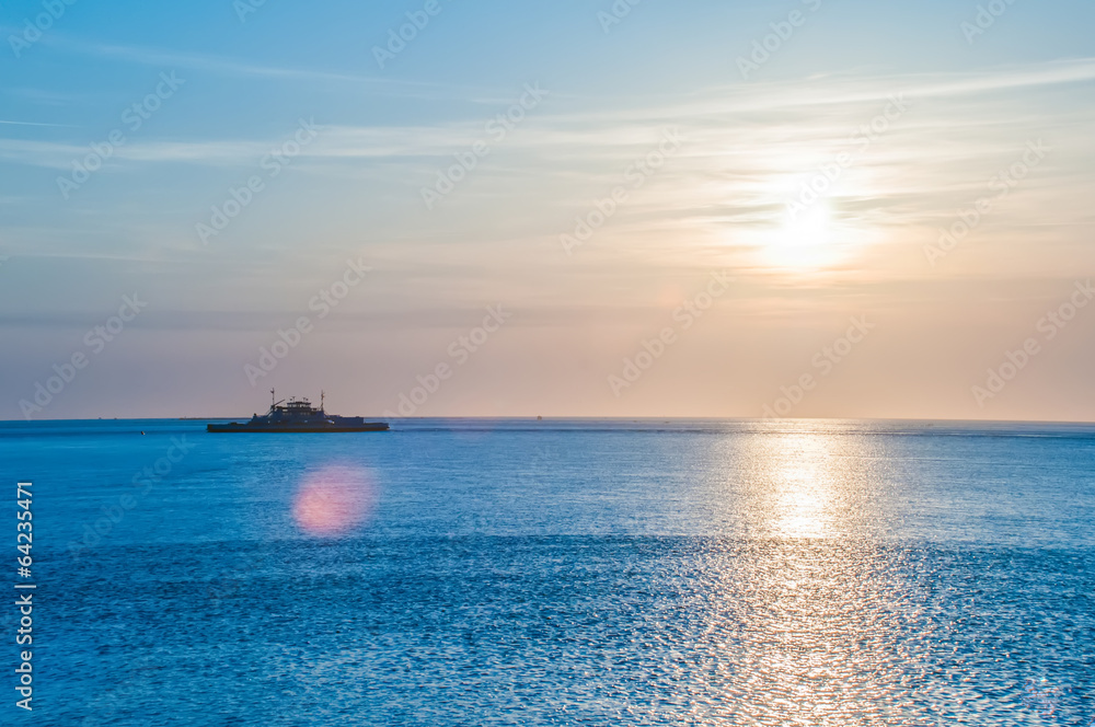 sunset on sea with ferry in distance