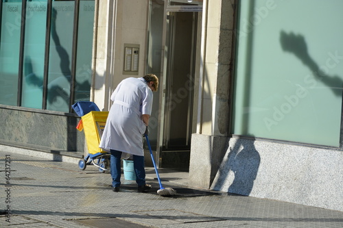 mujer de la limpieza fregando un portal photo