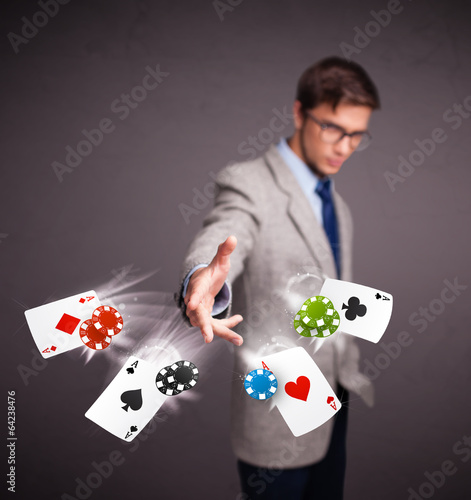 Young man playing with poker cards and chips