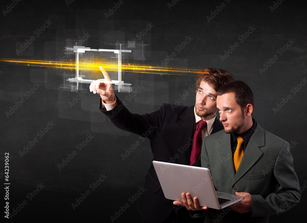 Young tech business people touching button with orange light bea Young tech business people touching button with orange light bea