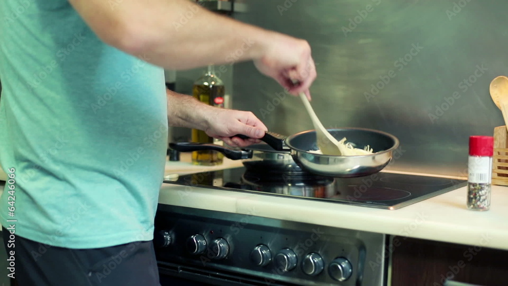 Man mixing and vegetables on frying pan Man mixing and vegetables on frying pan
