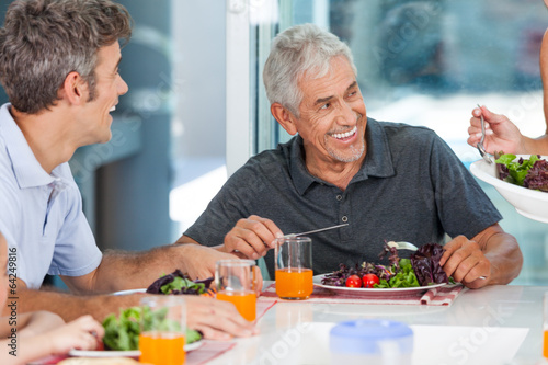 mature man with family dinner table