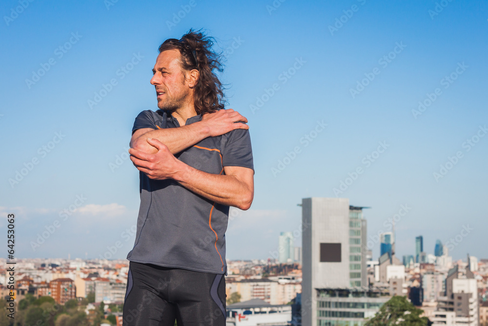 Long haired athlete stretching in a city park