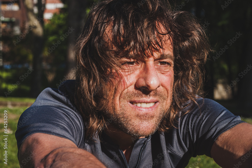 Long haired athlete stretching in a city park Long haired athlete stretching in a city park