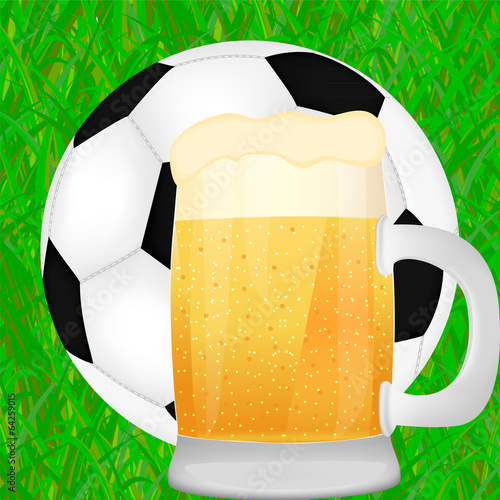 mug of beer and a soccer ball on green grass background