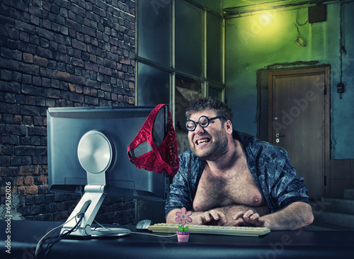 Man sitting at desk looking on computer screen photo