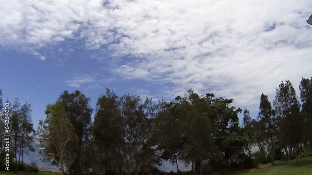 Time lapse of clouds and trees by the water during the day. Time lapse of clouds and trees by the water during the day.