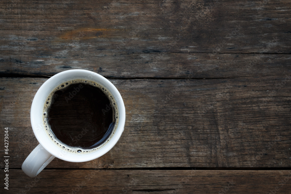 A white coffee cup on a wooden table background. A white coffee cup on a wooden table background.