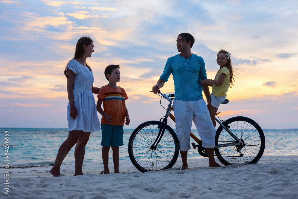 Family with a bike at tropical beach
