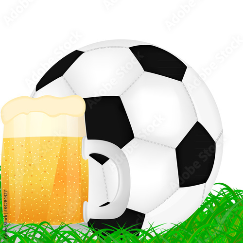 mug of beer and a soccer ball on green grass