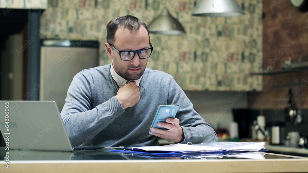 Businessman texting, using smartphone by the desk at home Businessman texting, using smartphone by the desk at home