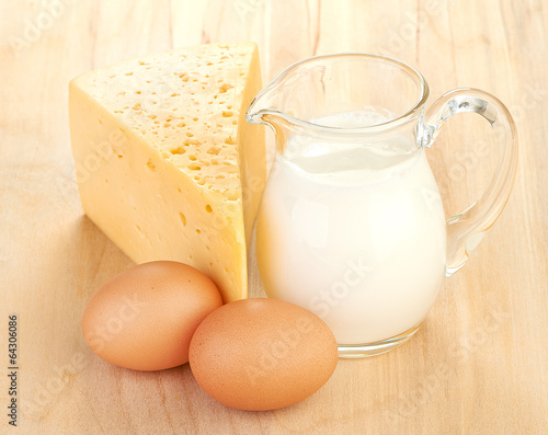 Big piece of cheese, glass jug with milk