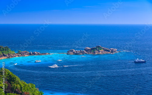 Aerial view of a beach with some motorboats in tropical sea