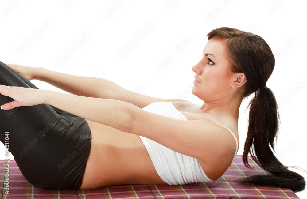 Fototapeta premium A young woman doing exercises, pumping a press