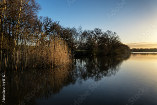 Stunning Spring sunrise landscape over lake with reflections and