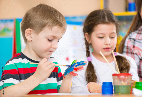Cute children painting at kindergarten photo