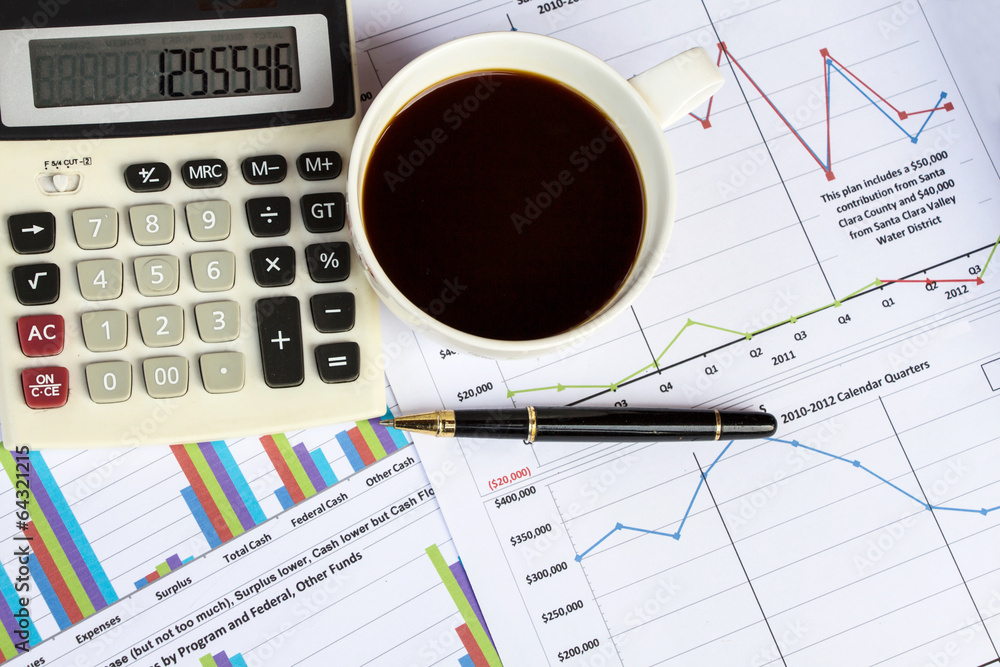 financial charts on the table with calculator, coffee and pen financial charts on the table with calculator, coffee and pen