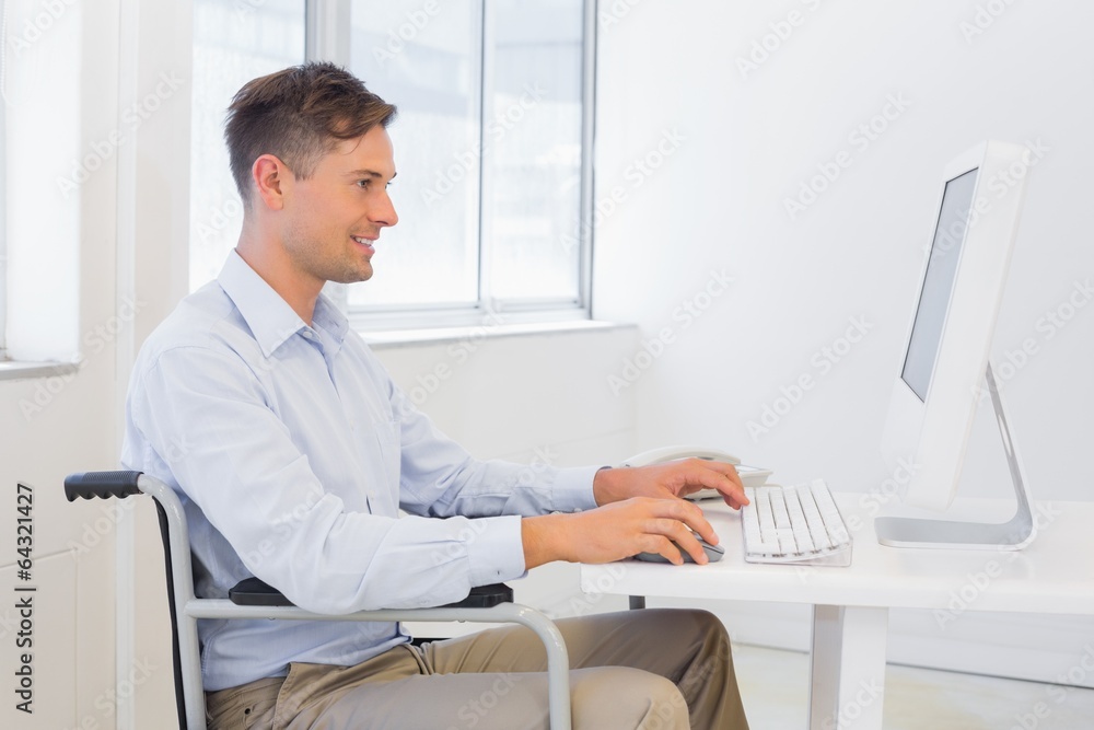 Casual businessman in wheelchair working at his desk Casual businessman in wheelchair working at his desk