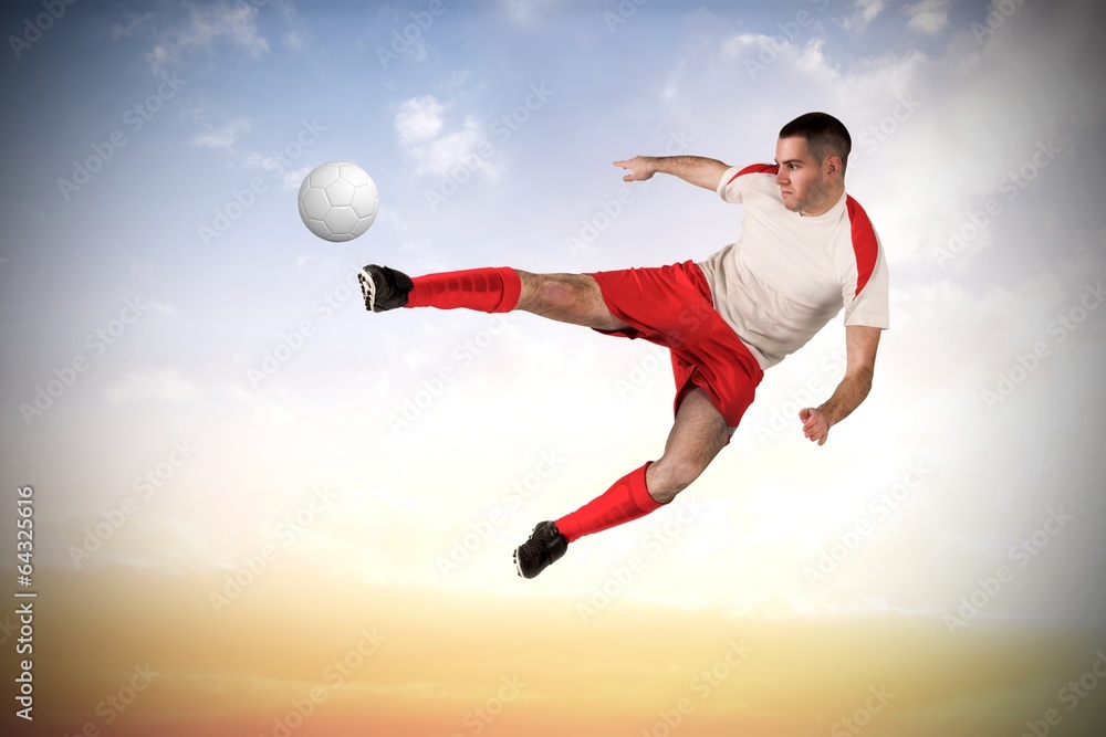 Fototapeta premium Composite image of fit football player playing and kicking
