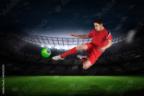 Composite image of fit football player jumping and kicking © WavebreakmediaMicro