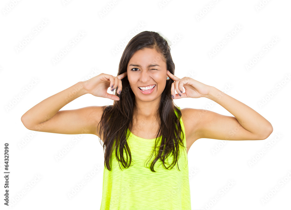 Portrait woman annoyed by loud noise plugging her ears Portrait woman annoyed by loud noise plugging her ears