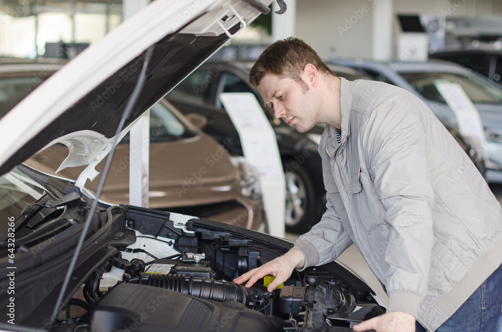 Man examining new car at the dealership. Man examining new car at the dealership.