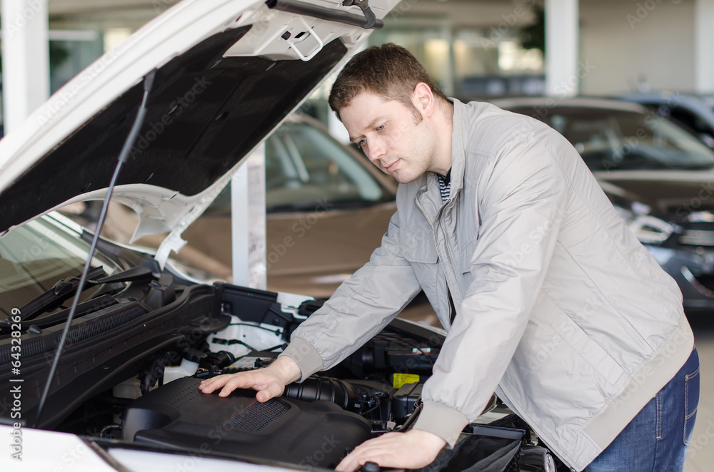Man examining new car at the dealership. Man examining new car at the dealership.