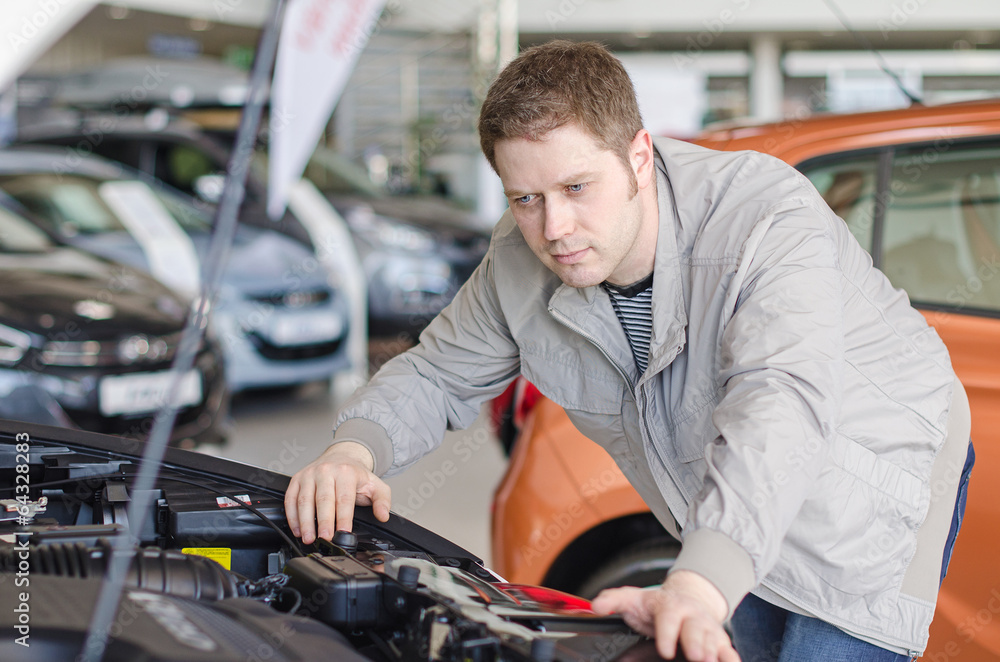 Man examining new car at the dealership. Man examining new car at the dealership.