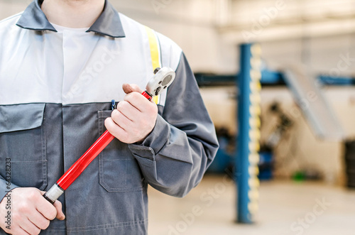 Mechanic with torque wrench at auto repair shop. photo