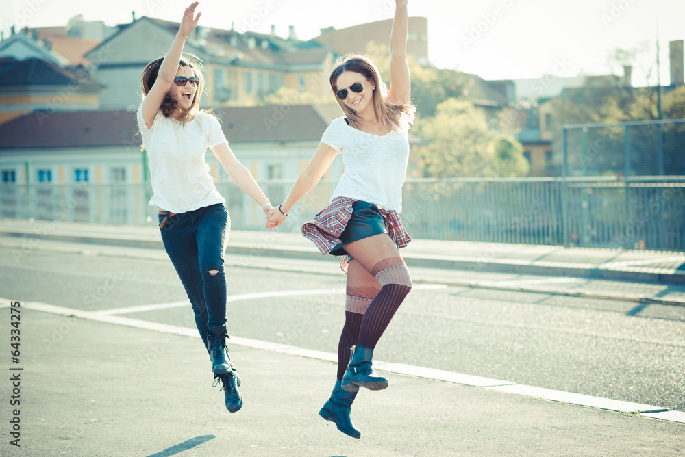 two beautiful young women jumping and dancing