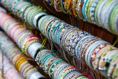Tubi ricoperti di  bracciali e collane di perline colorate photo