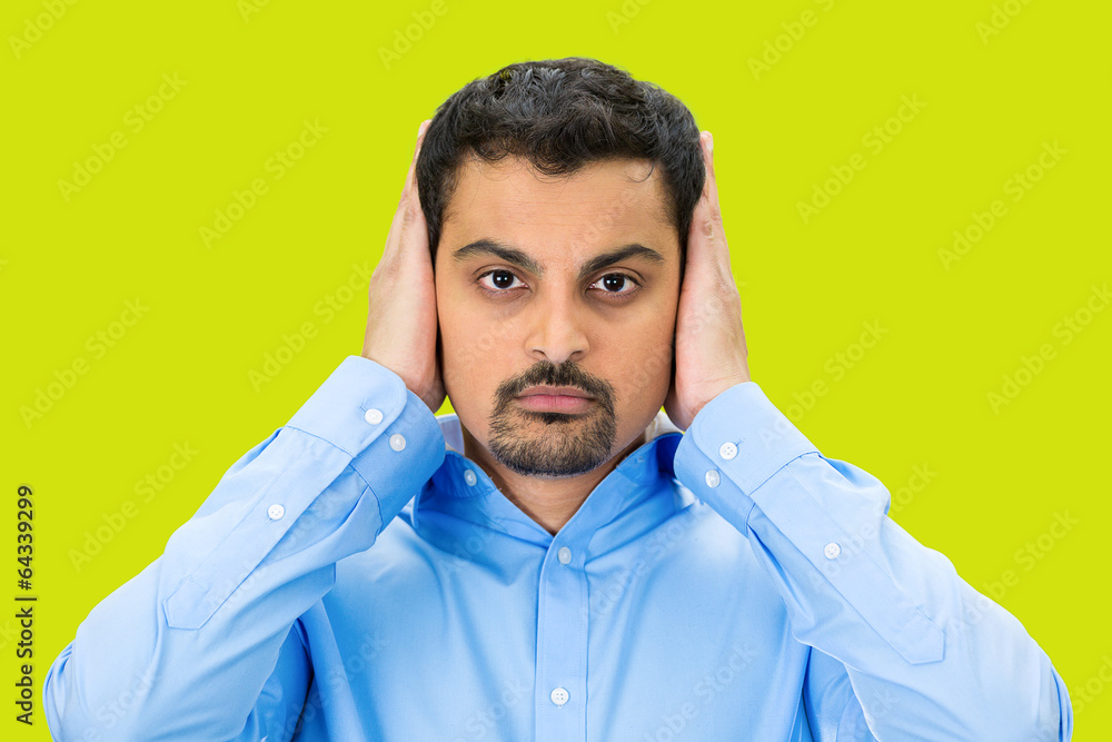 Hear no evil concept. Man covers his ears, green background Hear no evil concept. Man covers his ears, green background